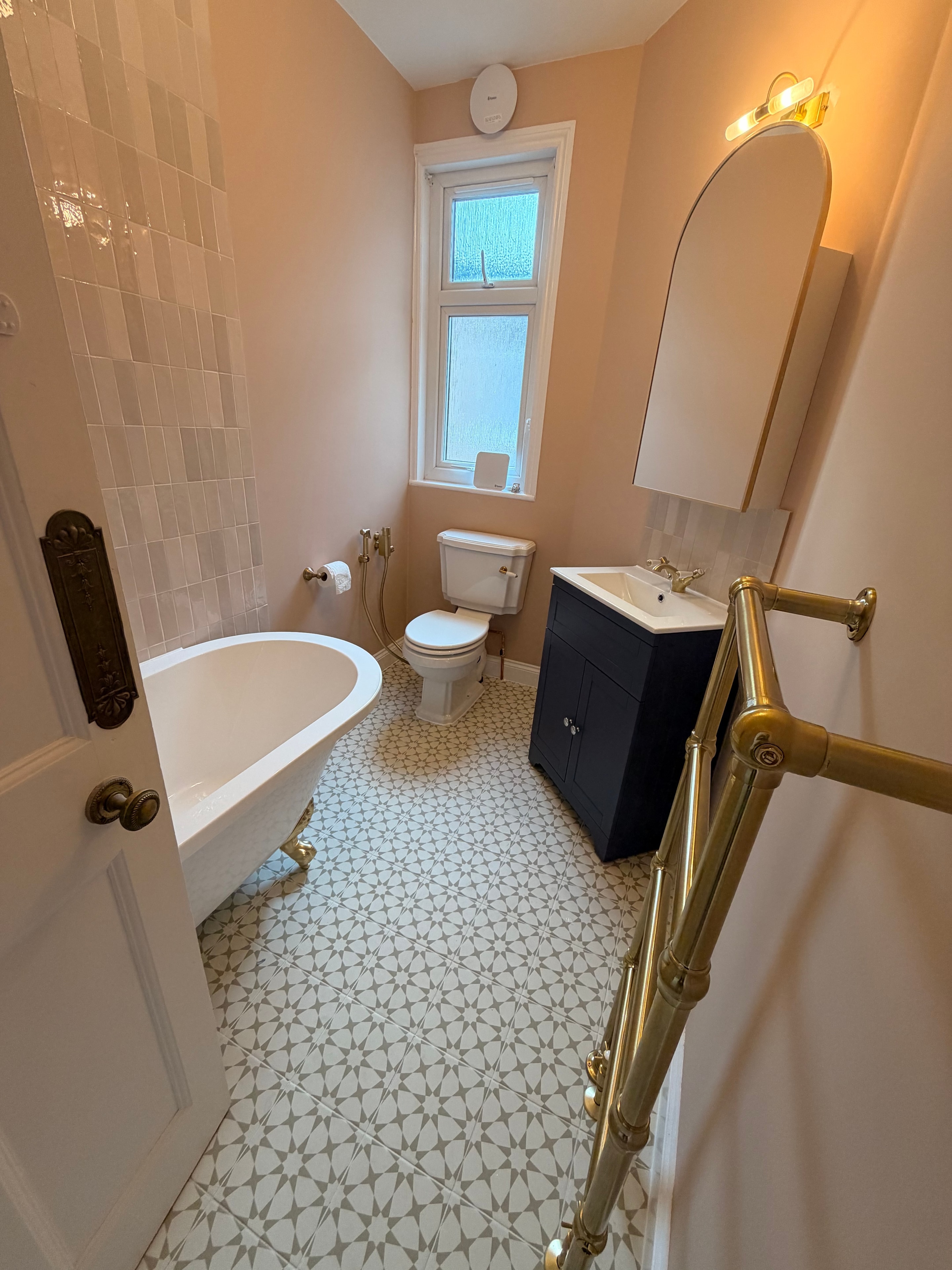 Completed bathroom fitting Watford — freestanding bath and patterned tiles